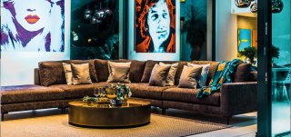 Jetset - Wohnbereich Wandbilder, Sofa braun, Zierkissen, Beistelltisch rund, Sofatisch, Teppich